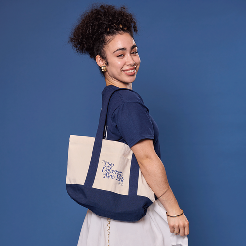 Person wearing a navy tote bag on a blue background